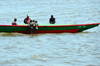 Cameroon, Douala: fishermen mend fishing nets in a wooden boat under the attentive eyes of children - Mboussa Sengu, near Douala Naval  Base - photo by M.Torres