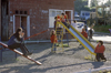 Chonchi, Chilo island, Los Lagos Region, Chile: children play on a slide - house with roof shingle covered walls - photo by C.Lovell