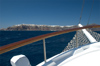 Greece, Cyclades, Santorini: view of distant Oia on the cliff edges from a cruise caique at sea - photo by P.Hellander