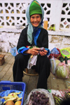 Laos: a smiling old woman is selling food at the market - photo by E.Petitalot