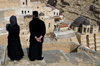 Mar Saba Monastery, West Bank, Palestine:  Greek Orthodox monk and female visitor overlooking the monastery - Great Lavra of St. Sabas - photo by J.Pemberton