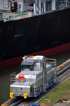 Panama Canal: Miraflores locks - electric locomotive guiding a vessel - 290 HP, built by Mitsubishi - these locos are known as 'mules' - photo by M.Torres